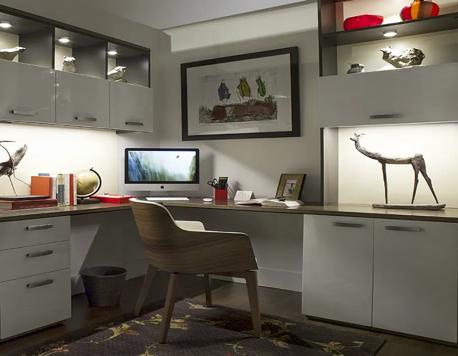 Custom home office with built-in cabinets, integrated lighting, display shelving, and organized workspace storage.